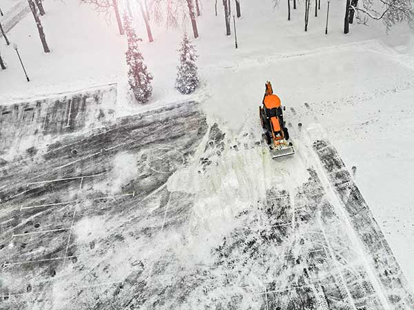 Aerial. Snow removal tractor cleans street from snow.