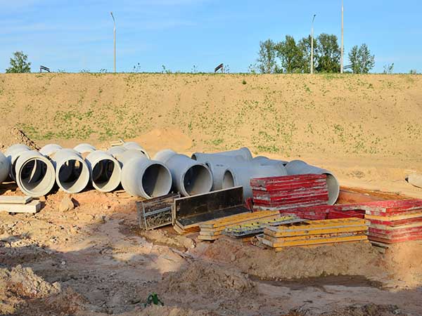 Laying or replacement of underground storm sewer pipes. Installation of water main, sanitary sewer, storm drain systems in city. Concrete drainage pipe. Utility Infrastructure - Image